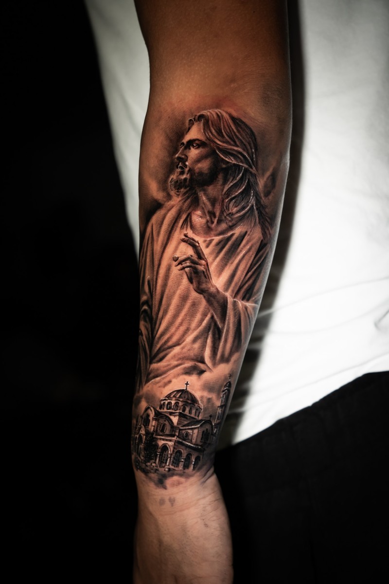 Black and grey Jesus tattoo with a church below the figure.